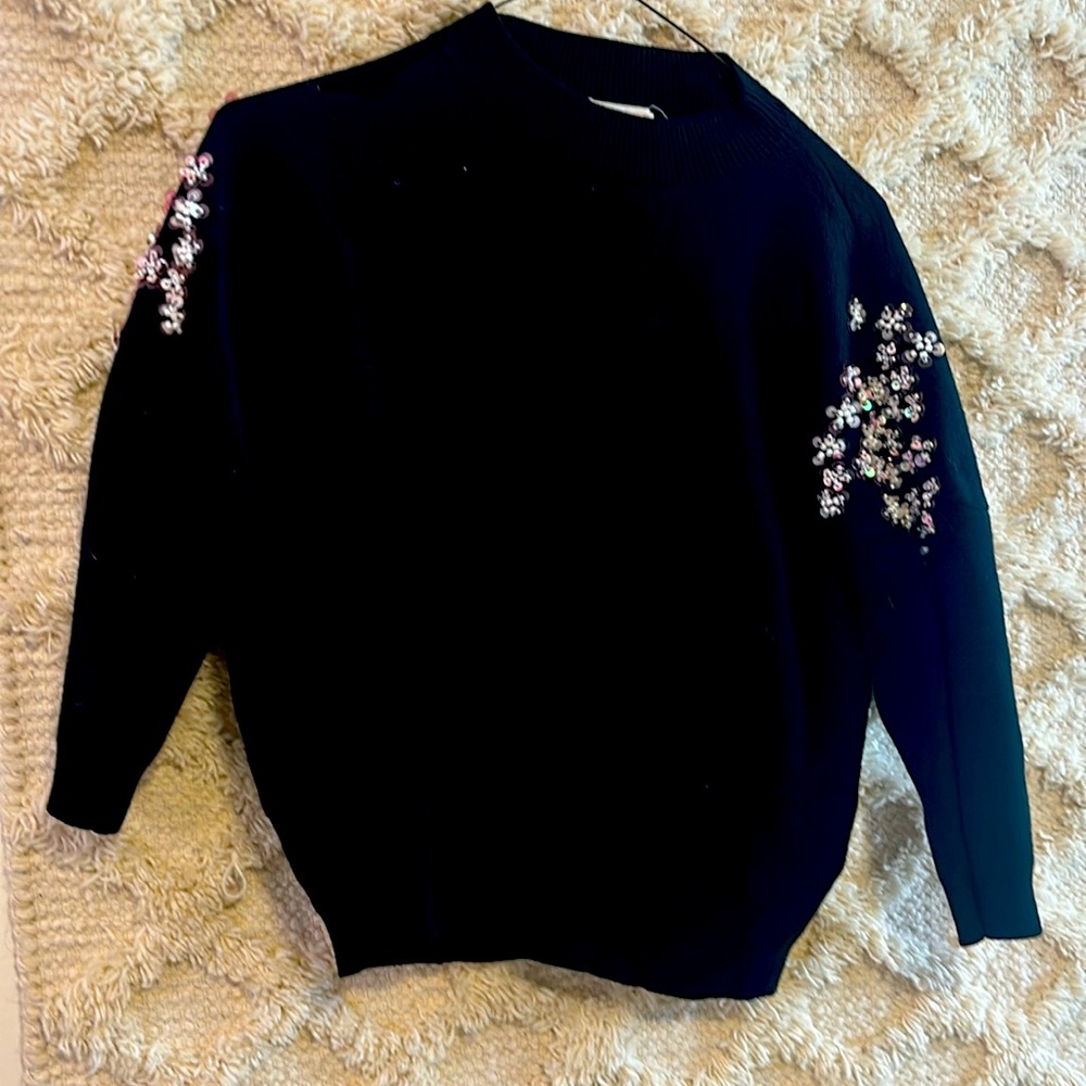 Black sweater with aplique on sleeves